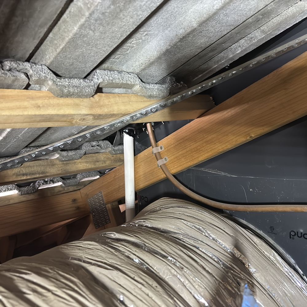 Evaporative cooler drain pipe discharging inside the roof space, flashing loose, found during a defect investigation in Winter Valley